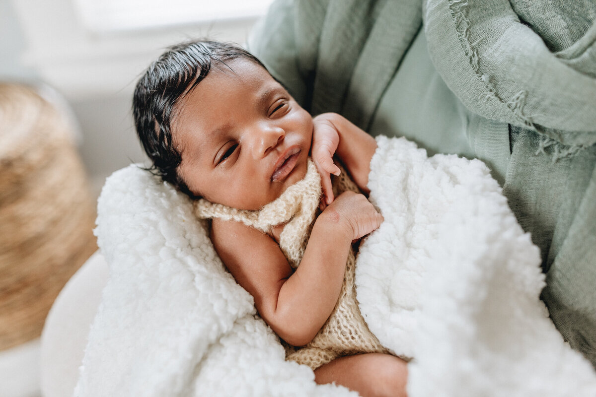 Lifestyle photography of mom holding newborn baby.