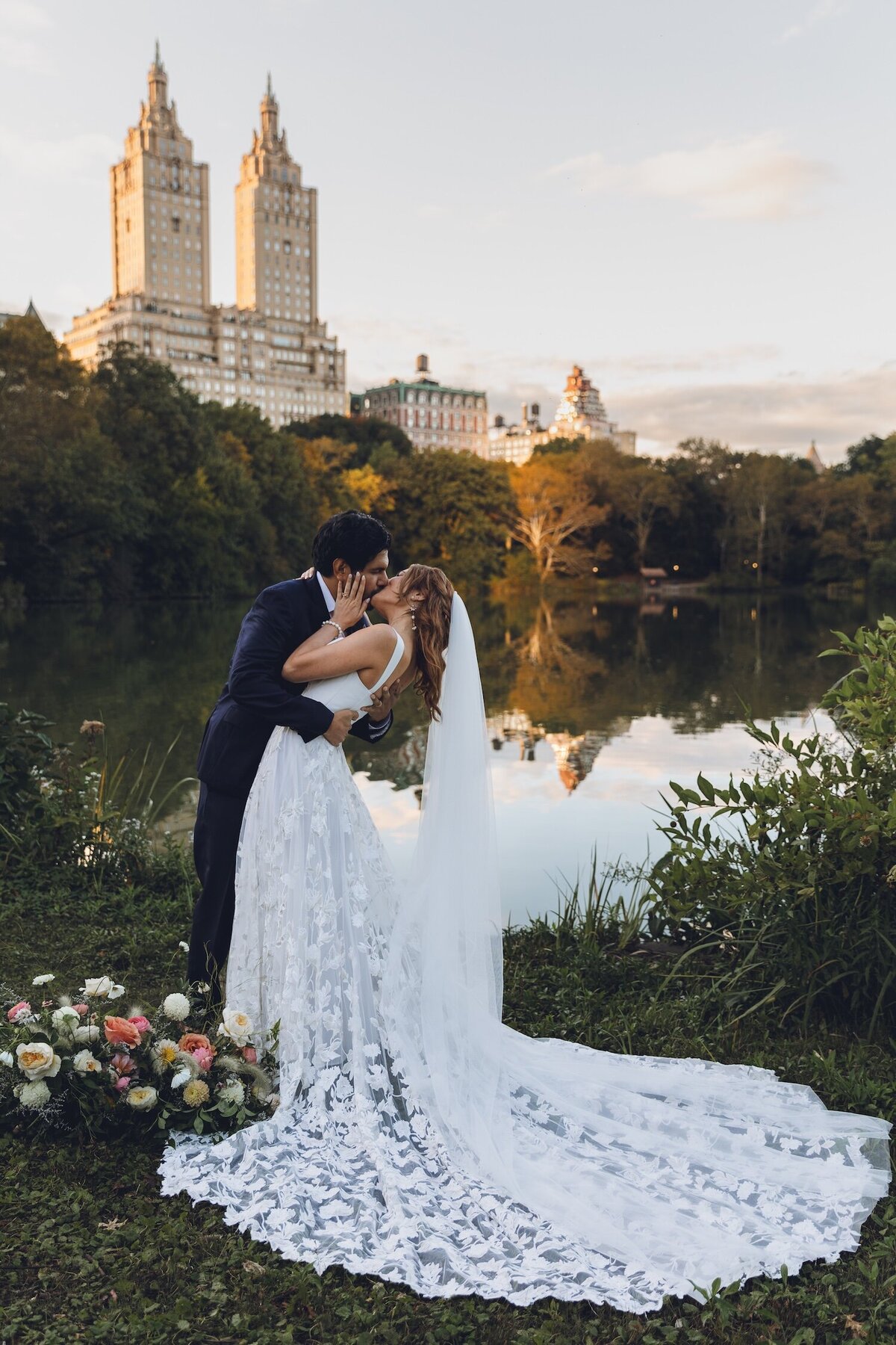 Joyful kiss during post-elopement champagne picnic