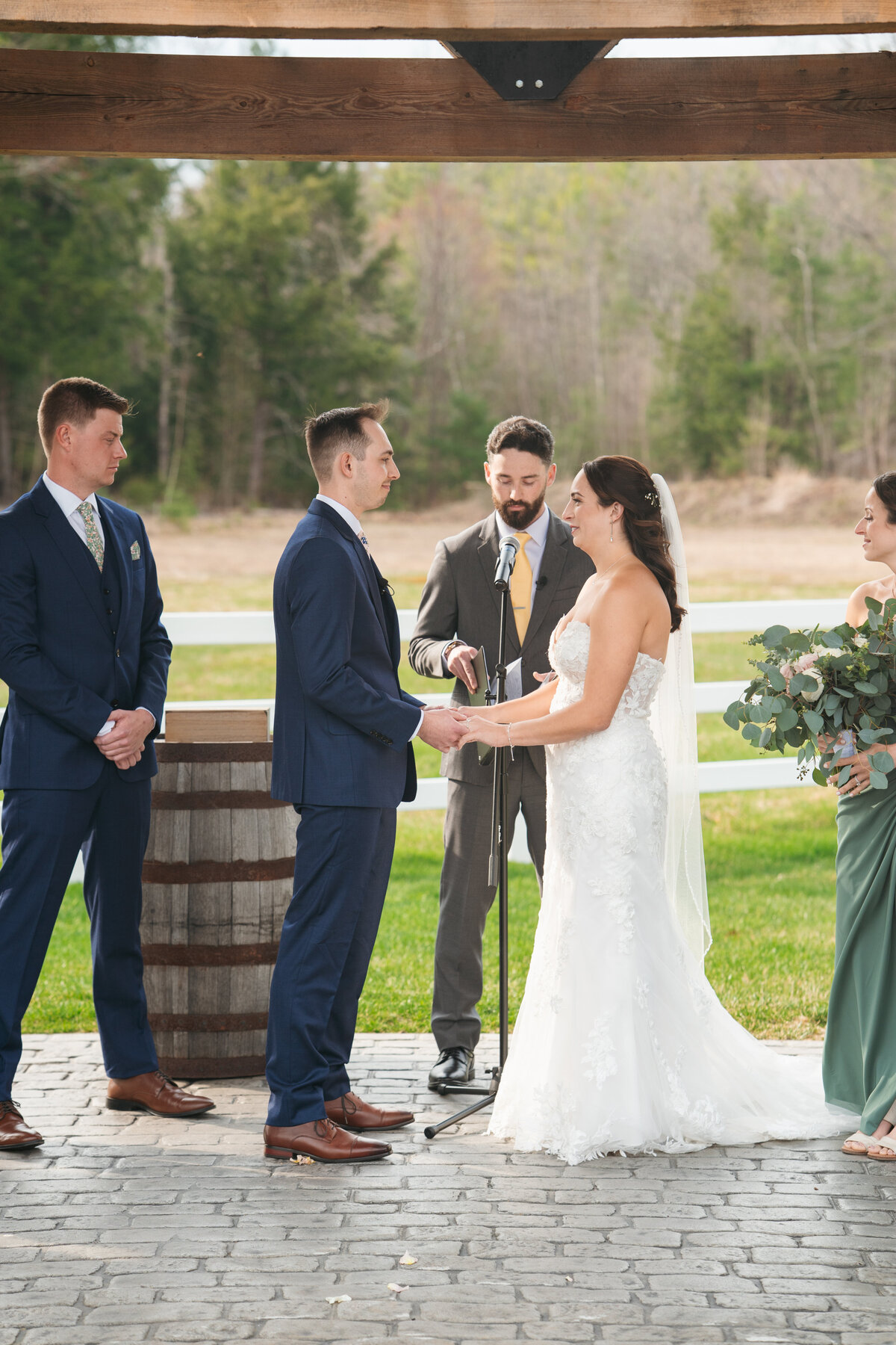 Couple exchanging vows under a floral arch in New England
