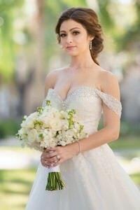 Beautiful bride in beaded off-shoulder wedding gown holding white rose bouquet, captured by professional St Augustine wedding photographer