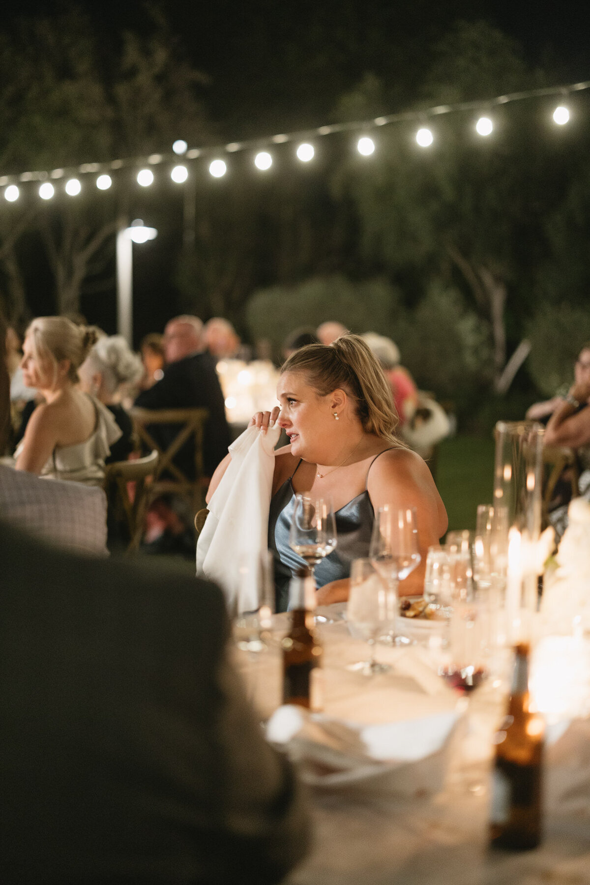 Guest wiping tears during father daughter dance at wedding reception