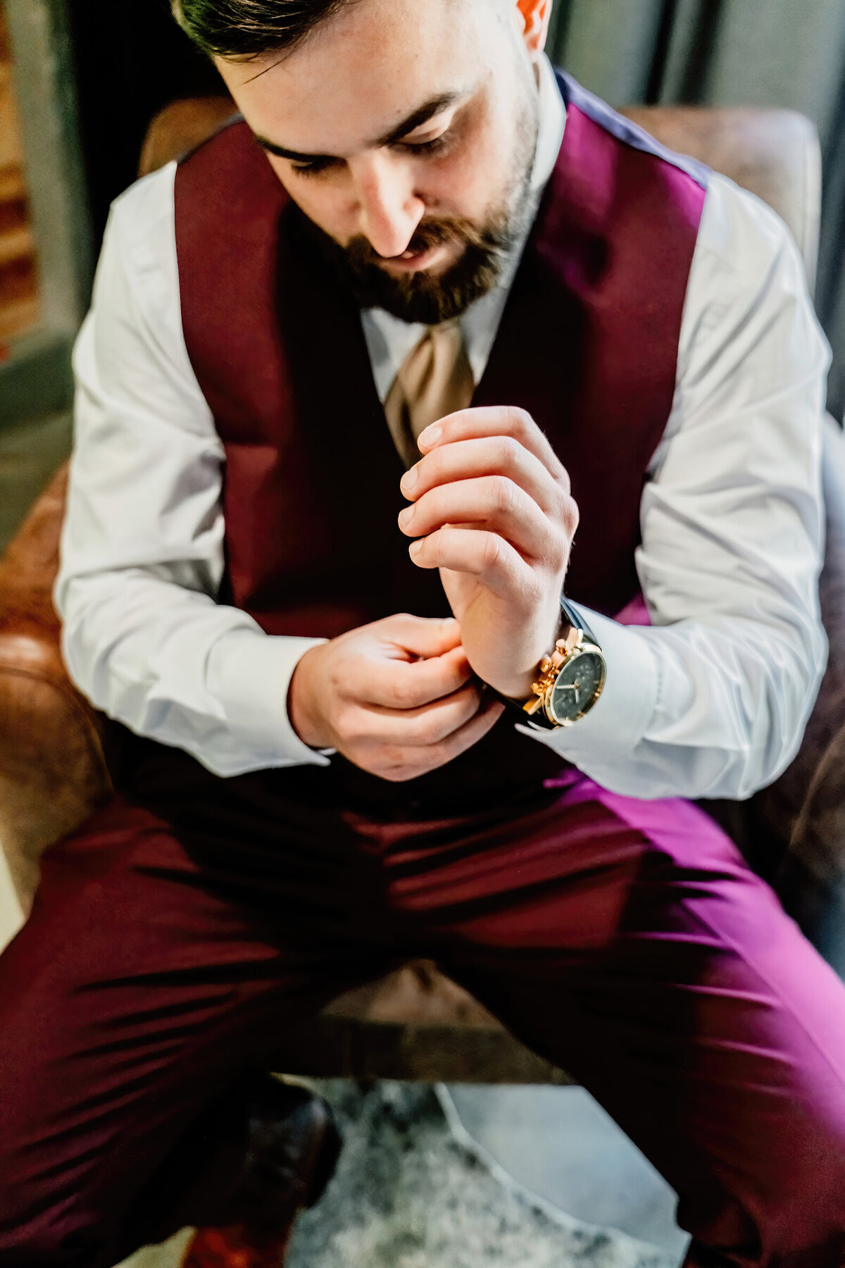 close up of groom putting on a watch his bride just got him