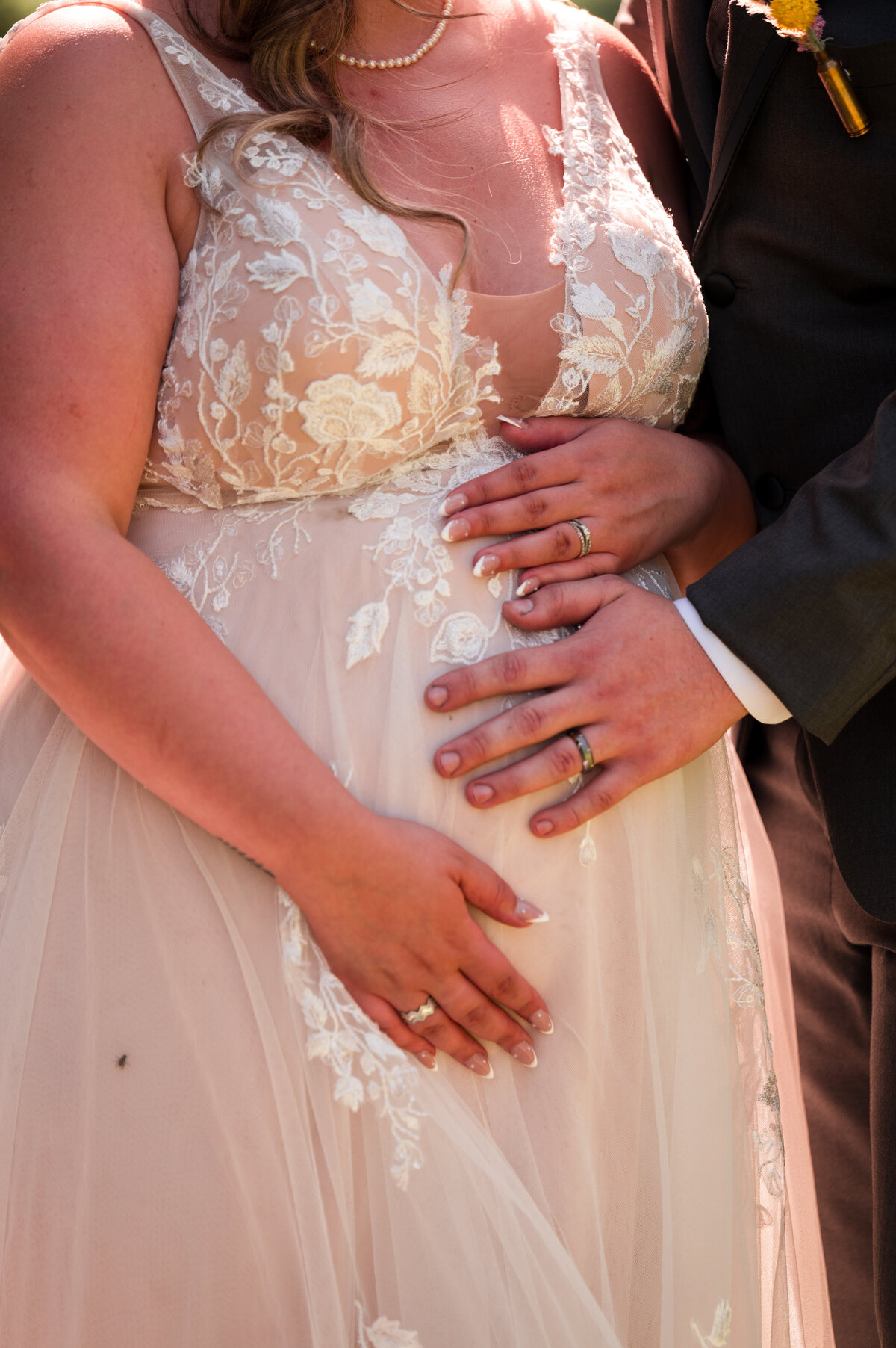 Pregnant bride on her wedding day shows off the baby bump with their rings