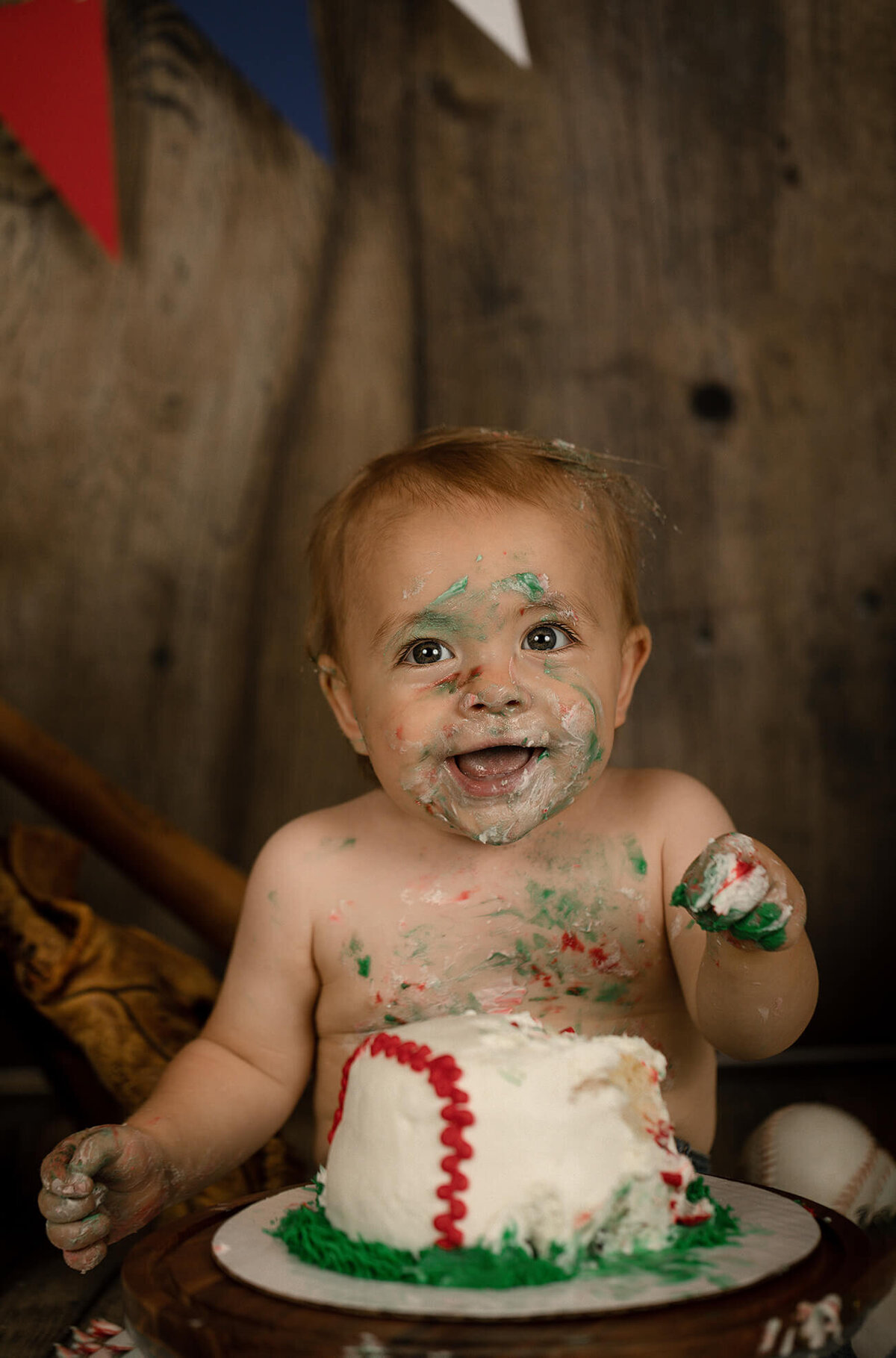 1 year old eating his baseball themed smash cake.