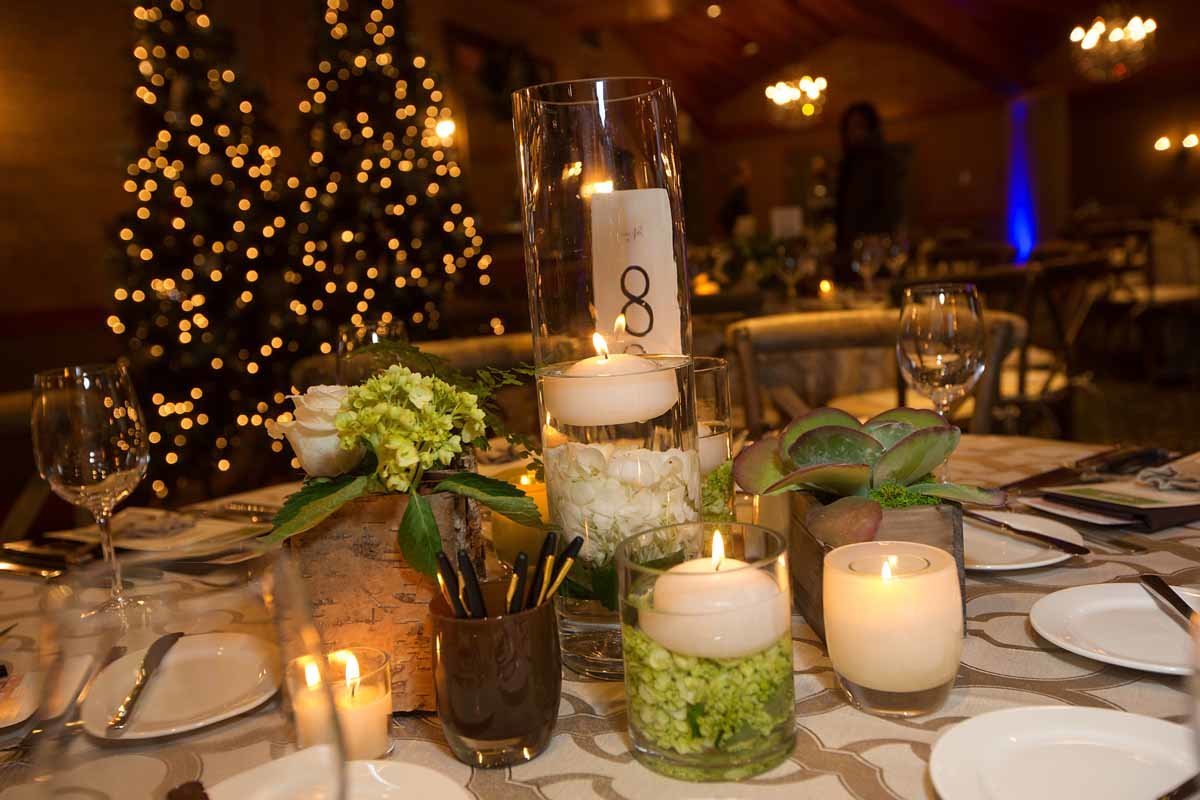 composite style centerpiece of floating candles, barked vase with succulents, vase with submerged hydrangea