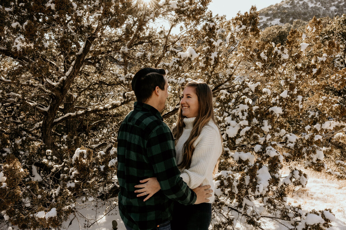 couple hugging on the  snowy Sandia foothills in Albuquerque