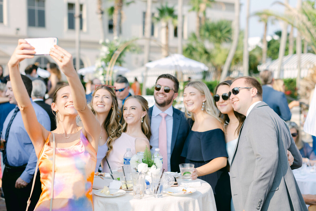 A wedding guest takes a selfie with her friends.