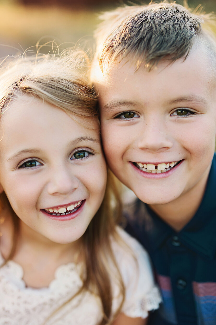 Close-up photo of brother and sister smiling at the camera