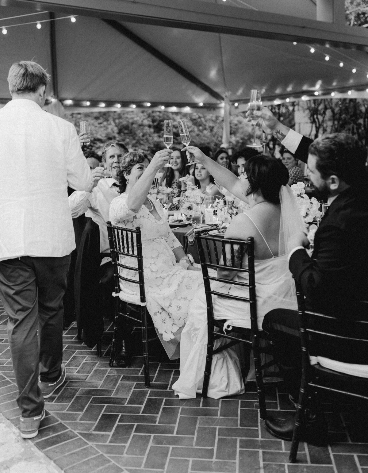 Wedding guests raising glasses at Umlauf Sculpture Garden, Austin