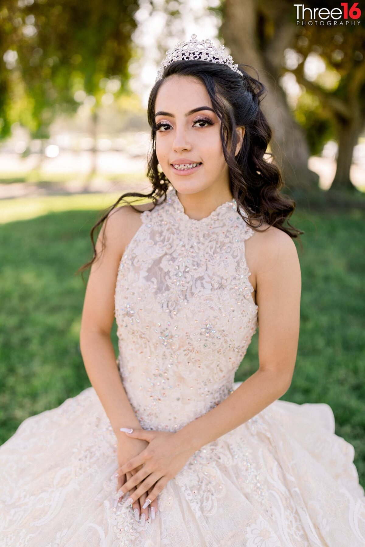 Young lady dressed in a white gown and a tiara celebrating her quinceanera