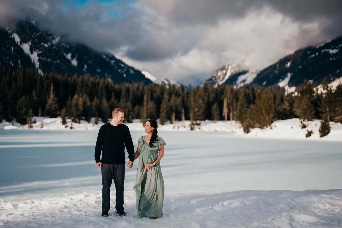 pregnant-woman-with-husband-in-snow-at-gold-creek-pond