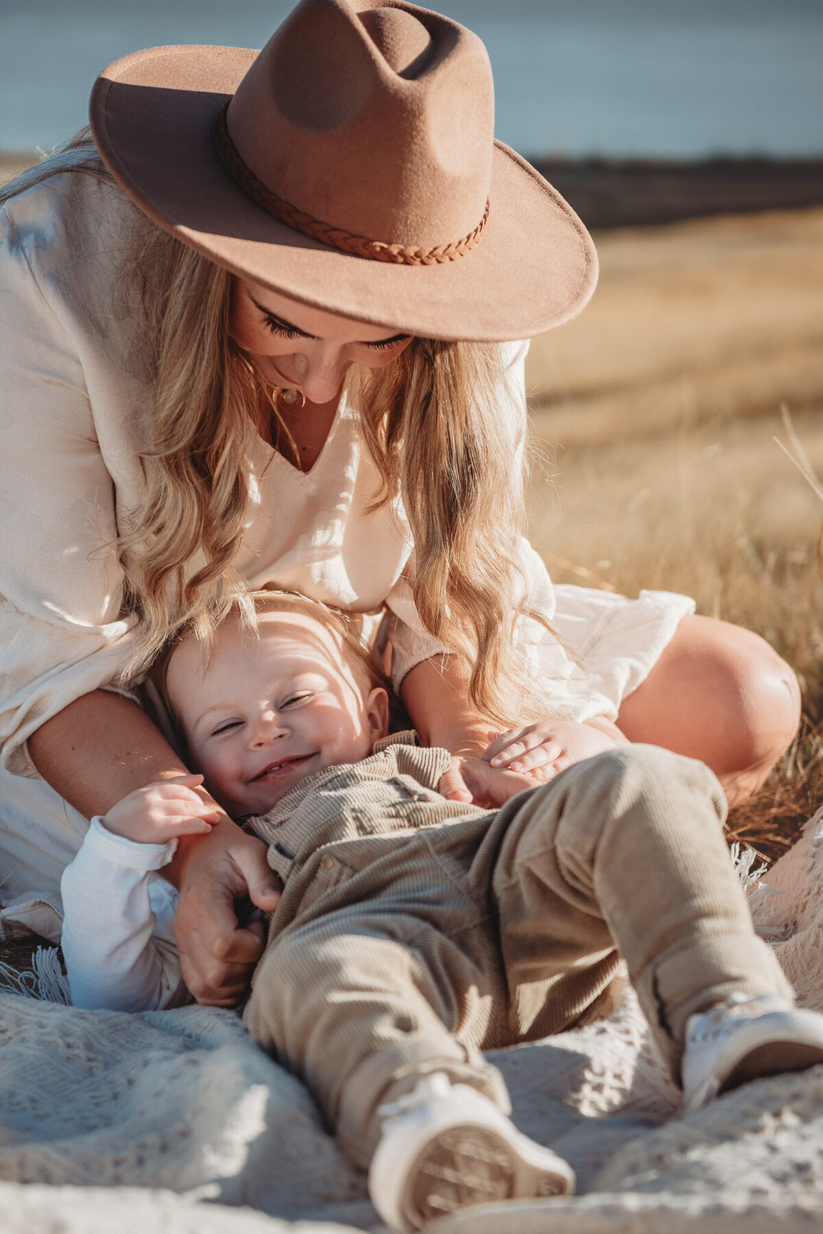 a mum tickling her boy during a photoshoot in wanaka, captured by Bie