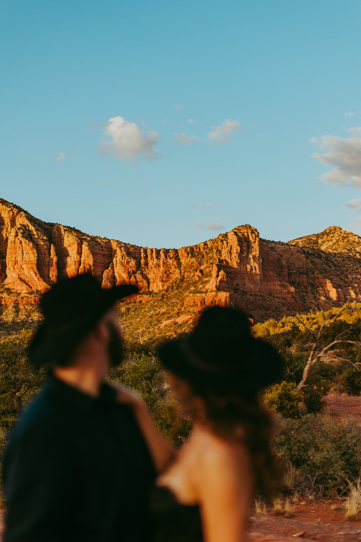 couple looks at the red rocks in sedoan for engagement photos
