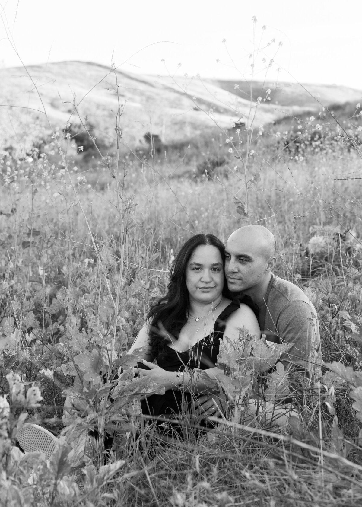 moody black and white engagement photo in open field