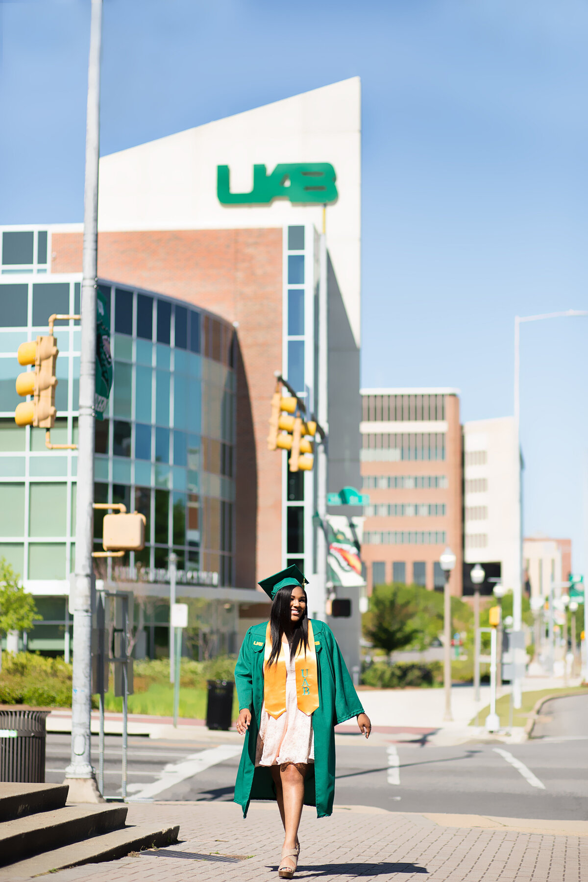 Aiyana walking in her cap and gown on UAB Campus for her grad session, in Birmingham, AL.