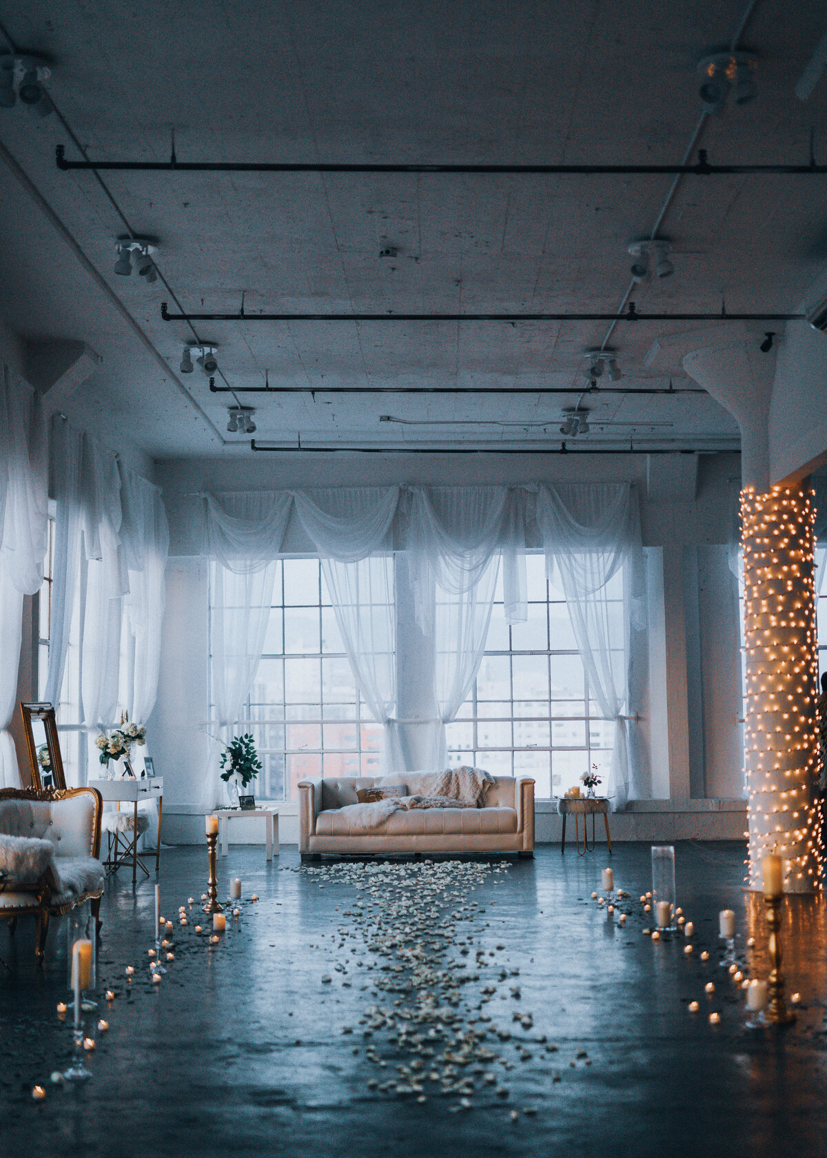 A warehouse loft apartment is set for a wedding proposal with rose petals, candles and fairy lights.