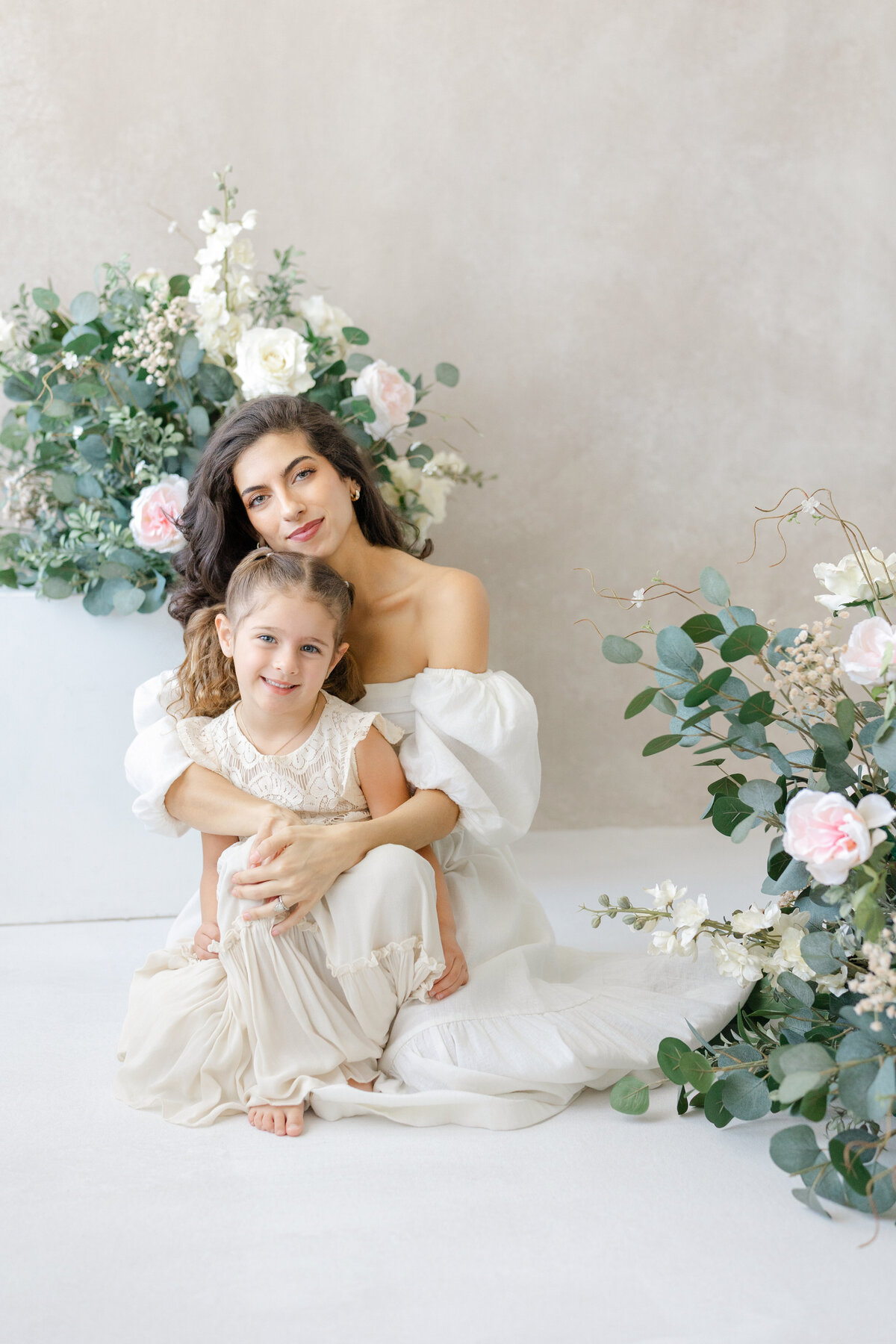 Joyful Tampa motherhood portrait of mom and daughter smiling in soft natural light studio