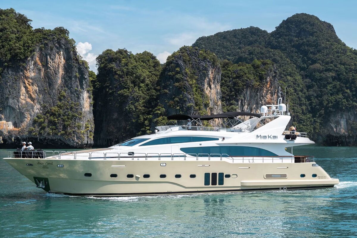 Private superyacht anchored near a secluded white sand beach in the Phi Phi Islands, Thailand.