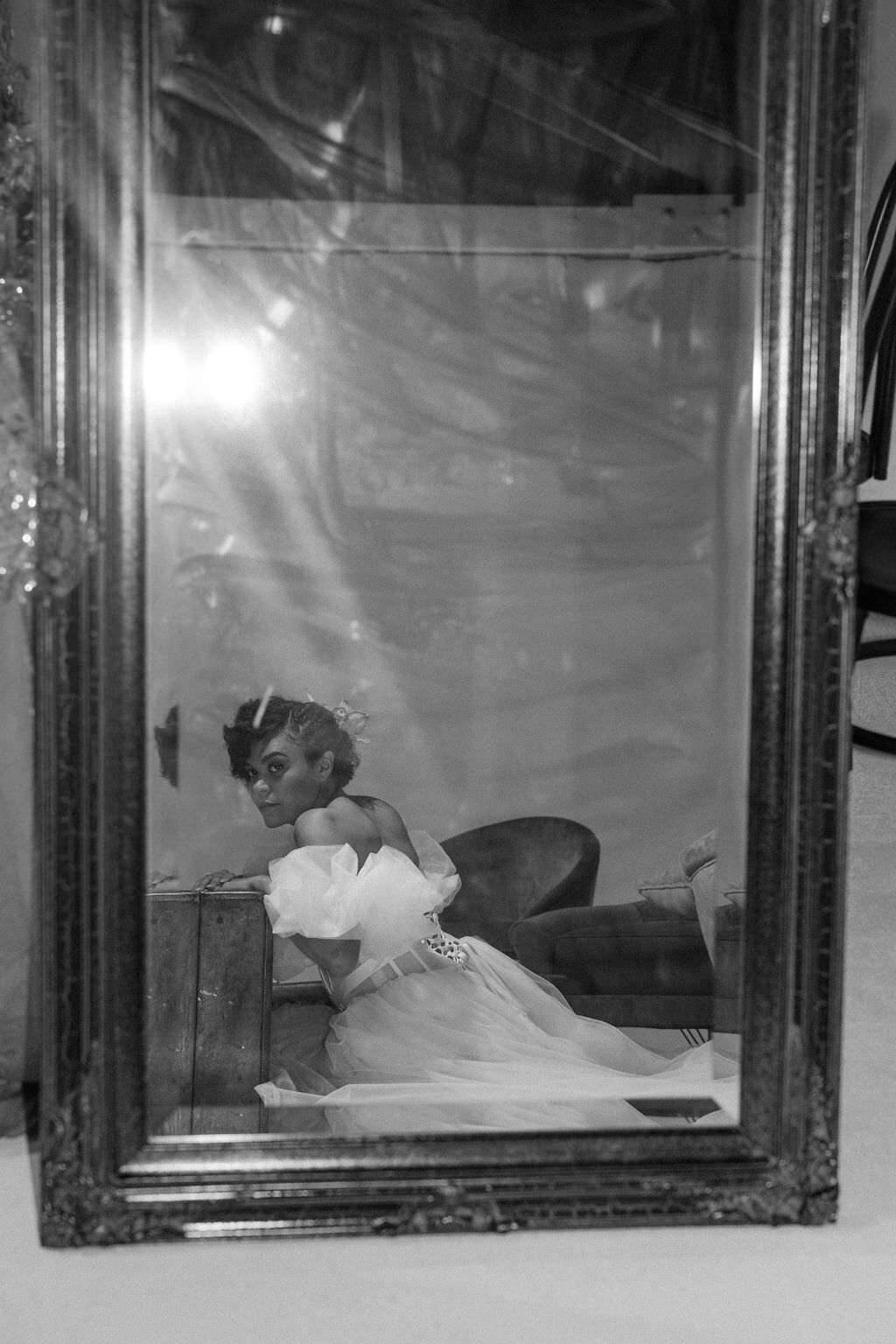 A person in a wedding dress looking into a mirror