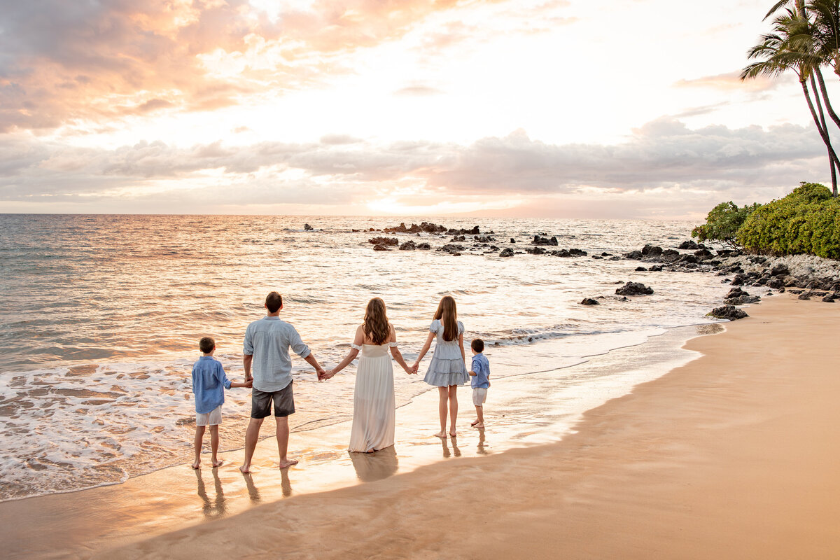 Maui Family Photographers capture beach family photos with family holding hands while walking on the beach