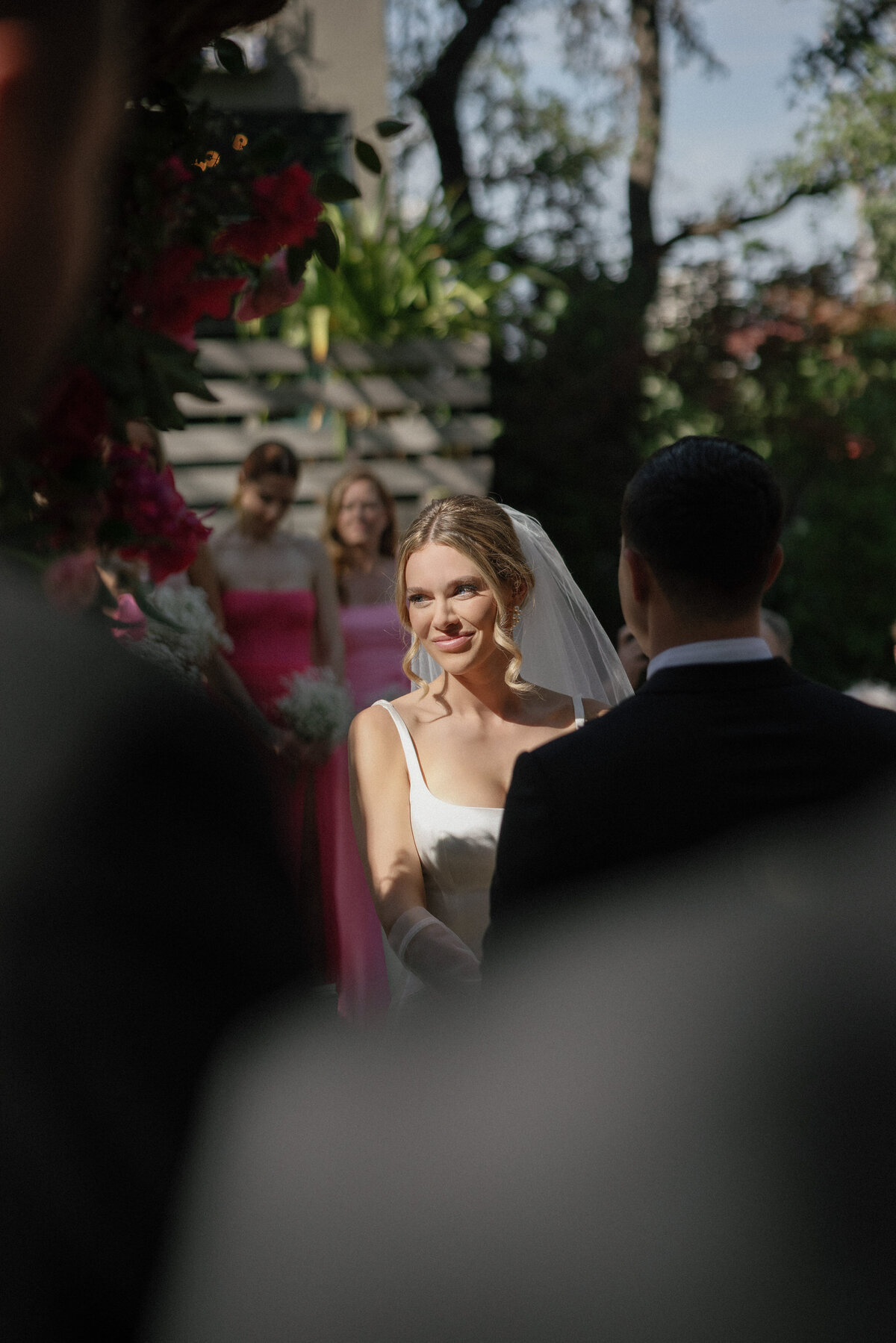 Bride standing in bright light at outdoor wedding ceremony