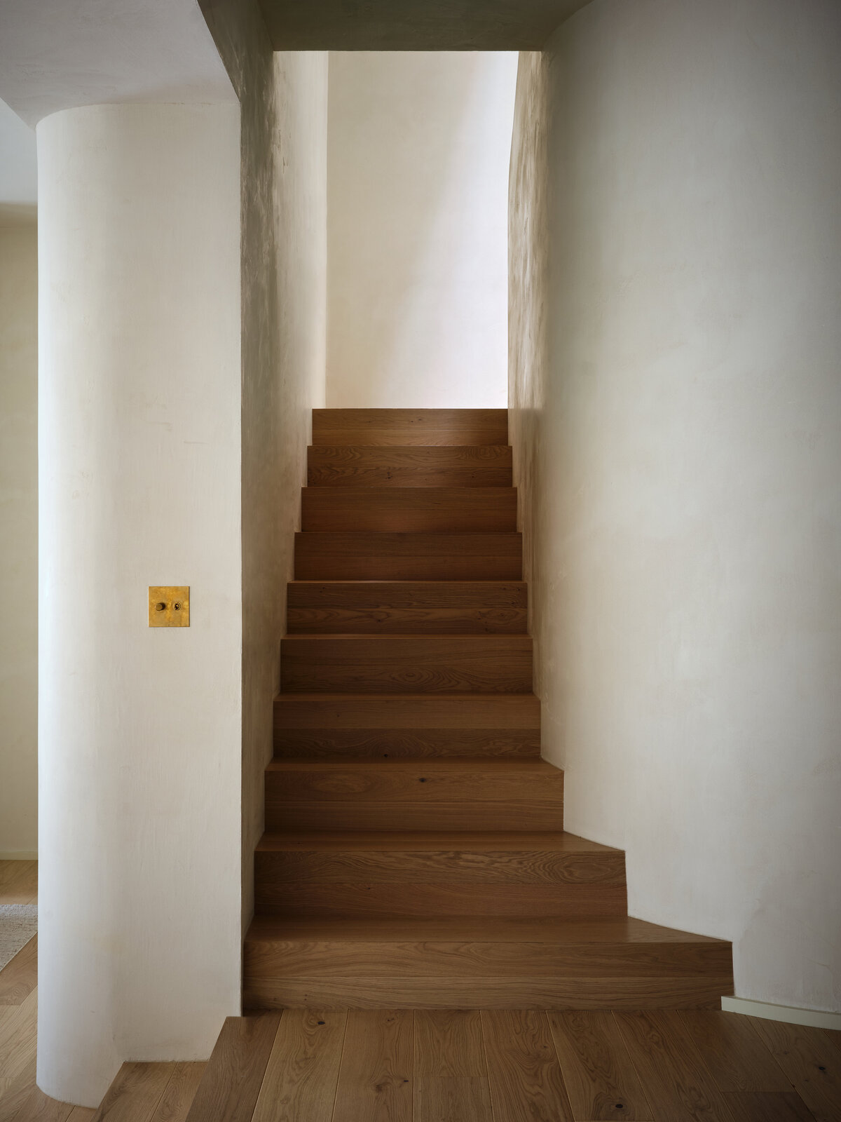 plaster-curved-wall-oak-stairs-waterfall-stairway-natural-light-skylight-austin-home-belgian-modern-house-franc