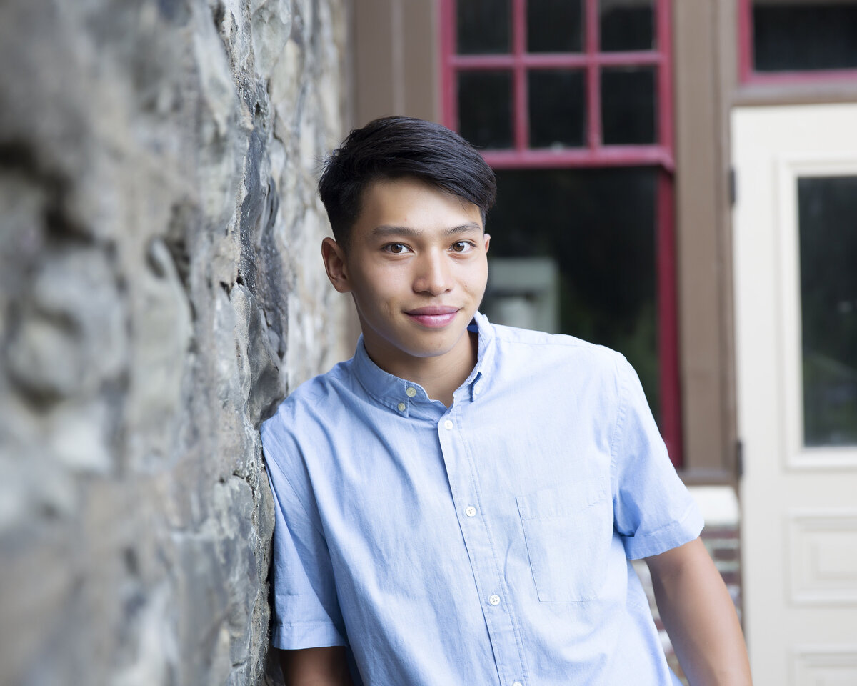 Hempfield area highschool senior poses against stone wall for his senior pictures with Murrysville photographer.