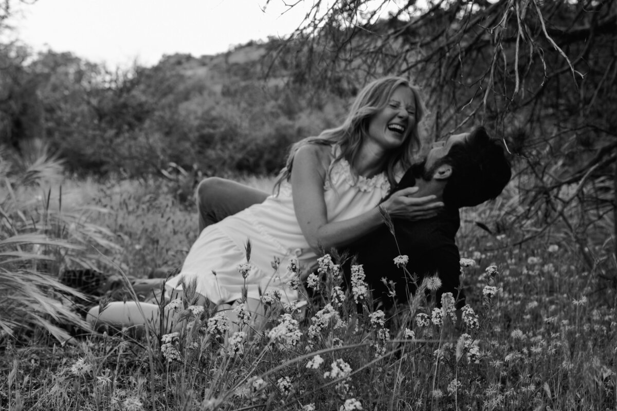 a couple laying in the grass laughing