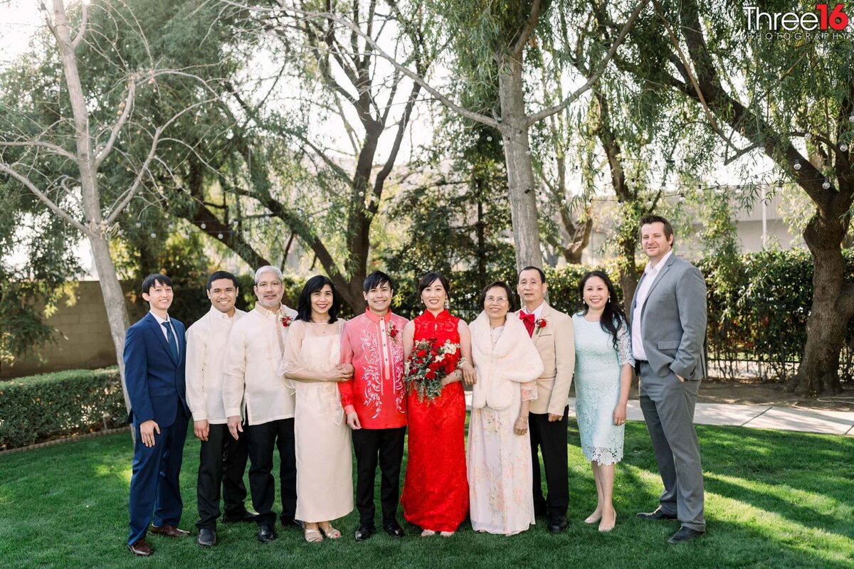 Bride and Groom pose for photos with their families together after the ceremony