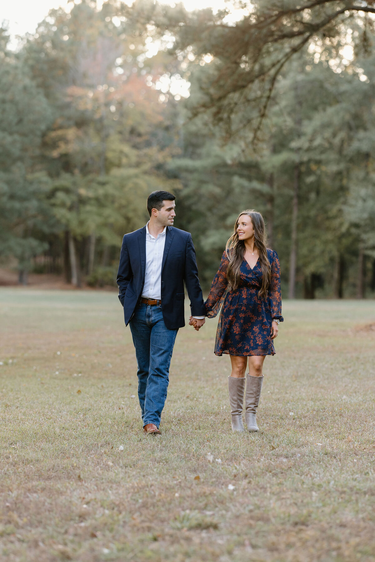 Longview, TX couple holding hands and walking through open field