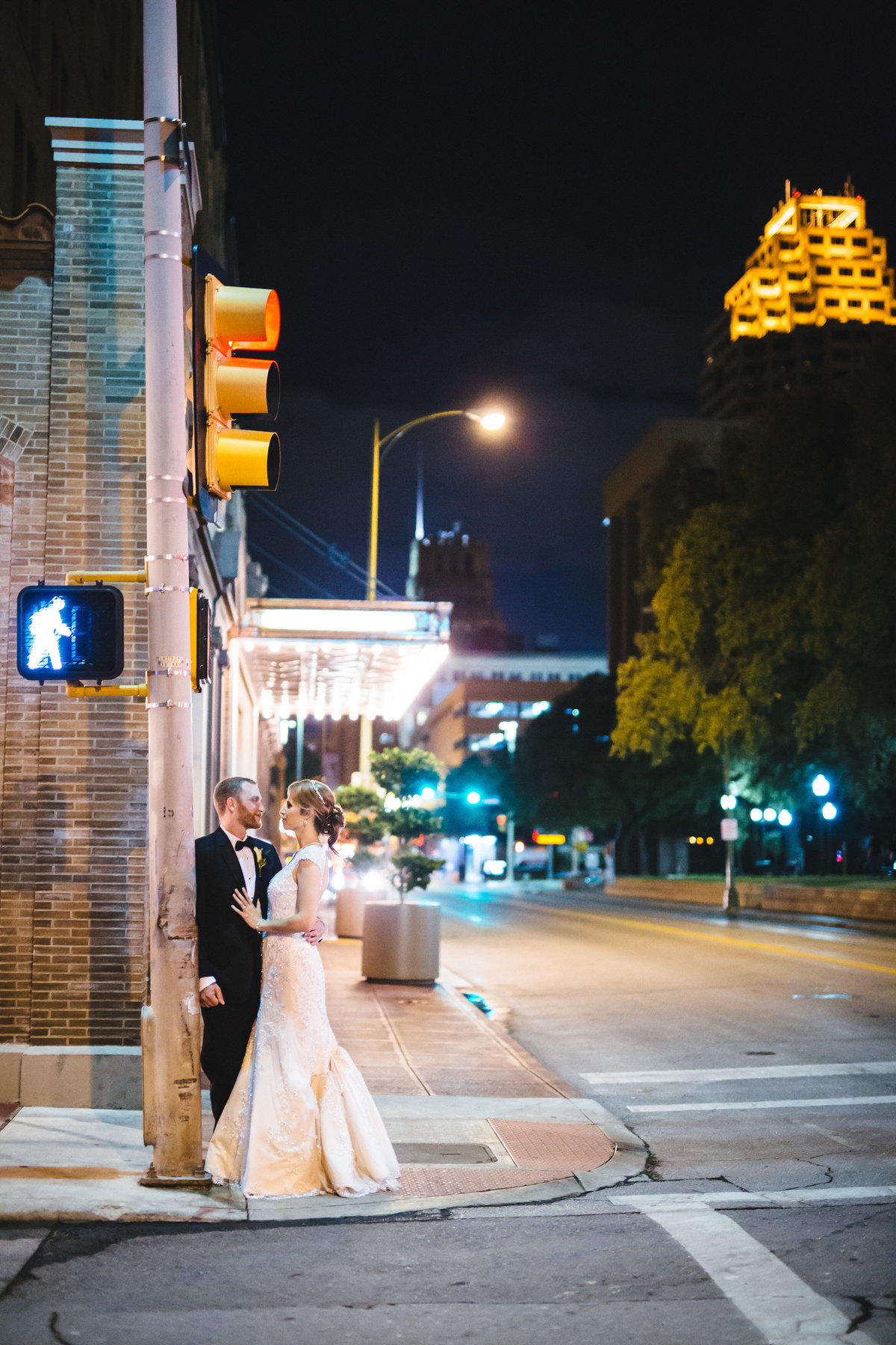 Bride leaning into her groom during the wedding reception in front of the St. Anthony Hotel in San Antonio
