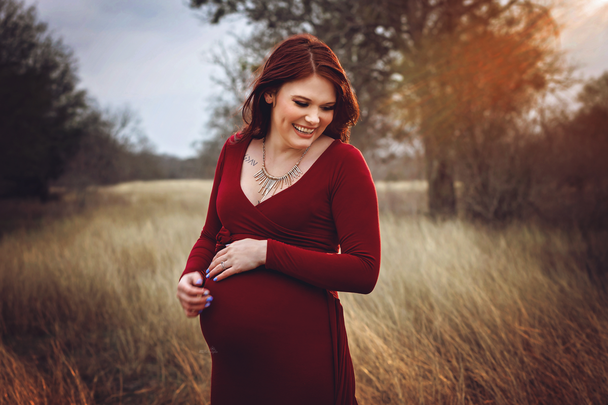 Step into a scarlet dream with our styled maternity session in a winter field near San Antonio. Laid-back parents, capture magical moments with our mom-to-be in her flying dress.