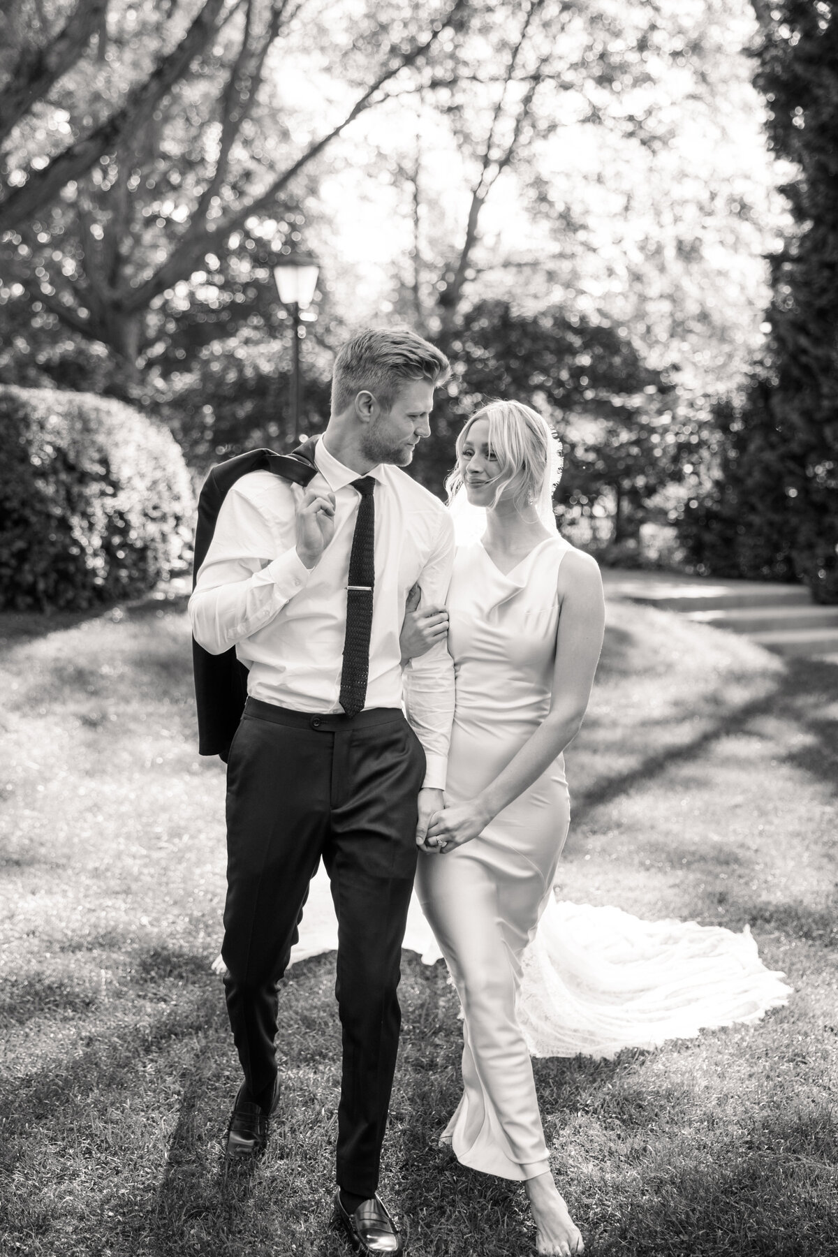 Couple walks hand-in-hand in black and white at Dayton, Ohio wedding, by a Philadelphia wedding photographer.
