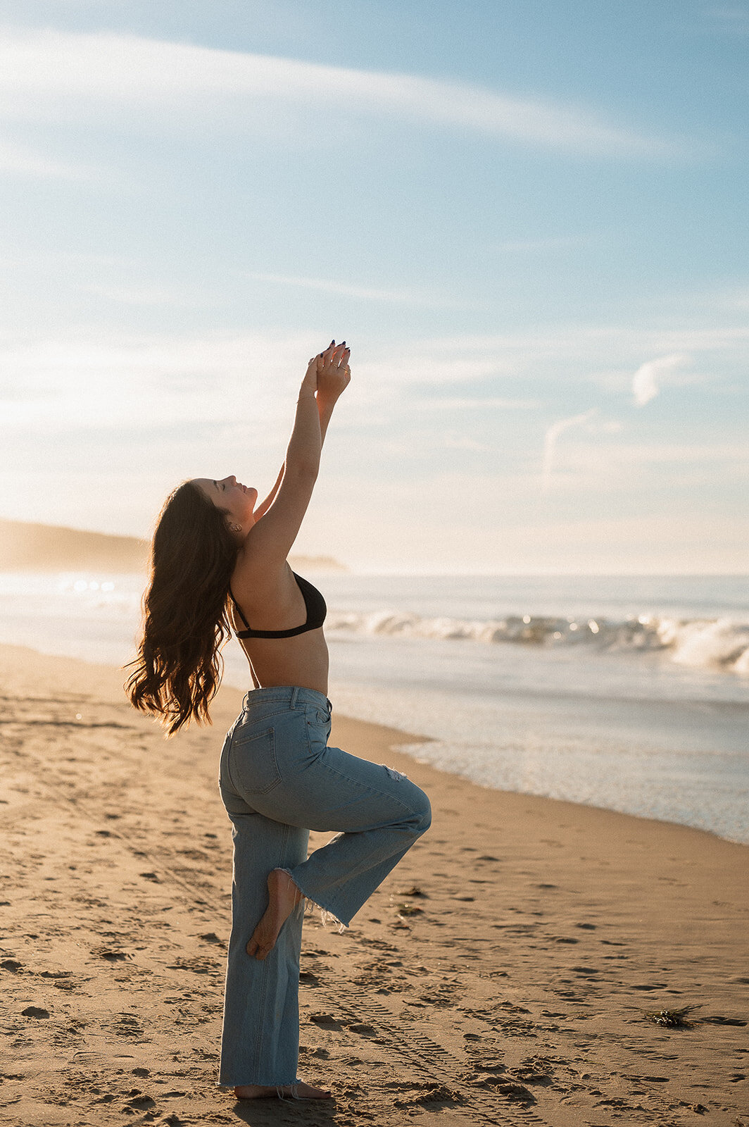photo of senior graduate dancing on sand