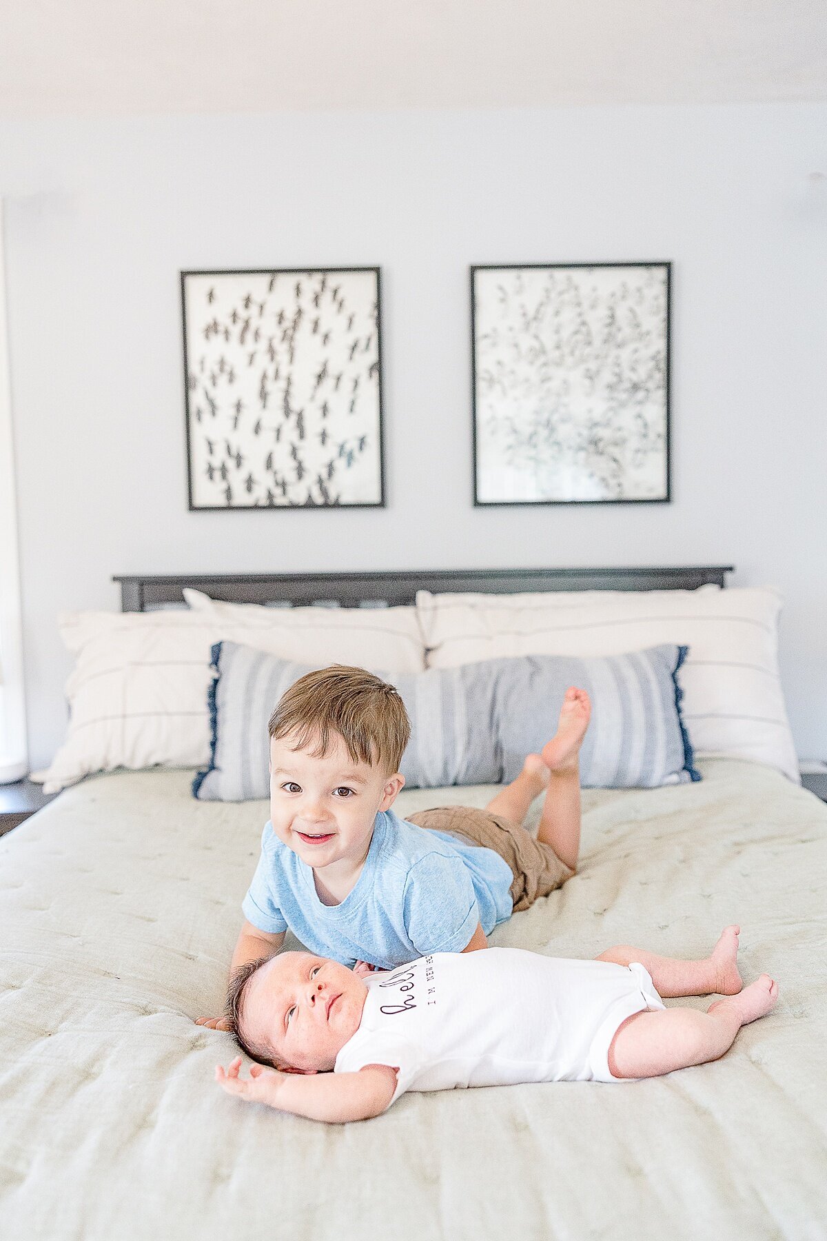 brothers sit on bed dung in-home newborn photo session with Sara Sniderman Photography in metro west Boston  Massachusetts