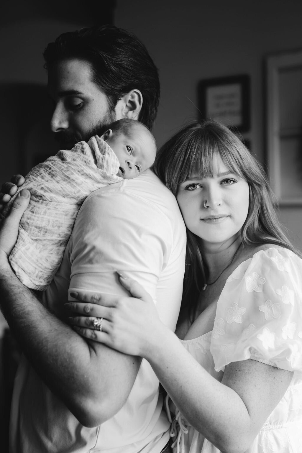 Classic black and white image of parents holding newborn in Austin