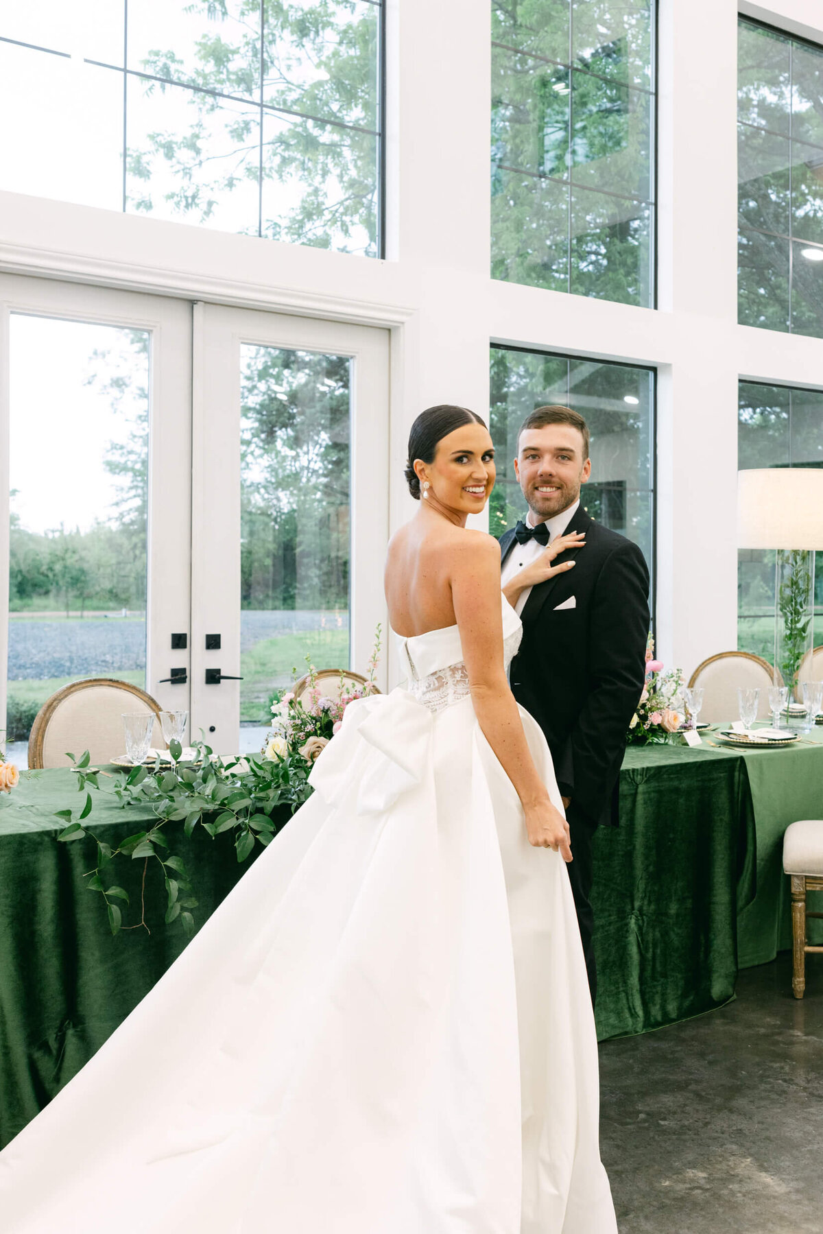 A wedding day photo of the bride and groom posing for a photo in the wedding reception area