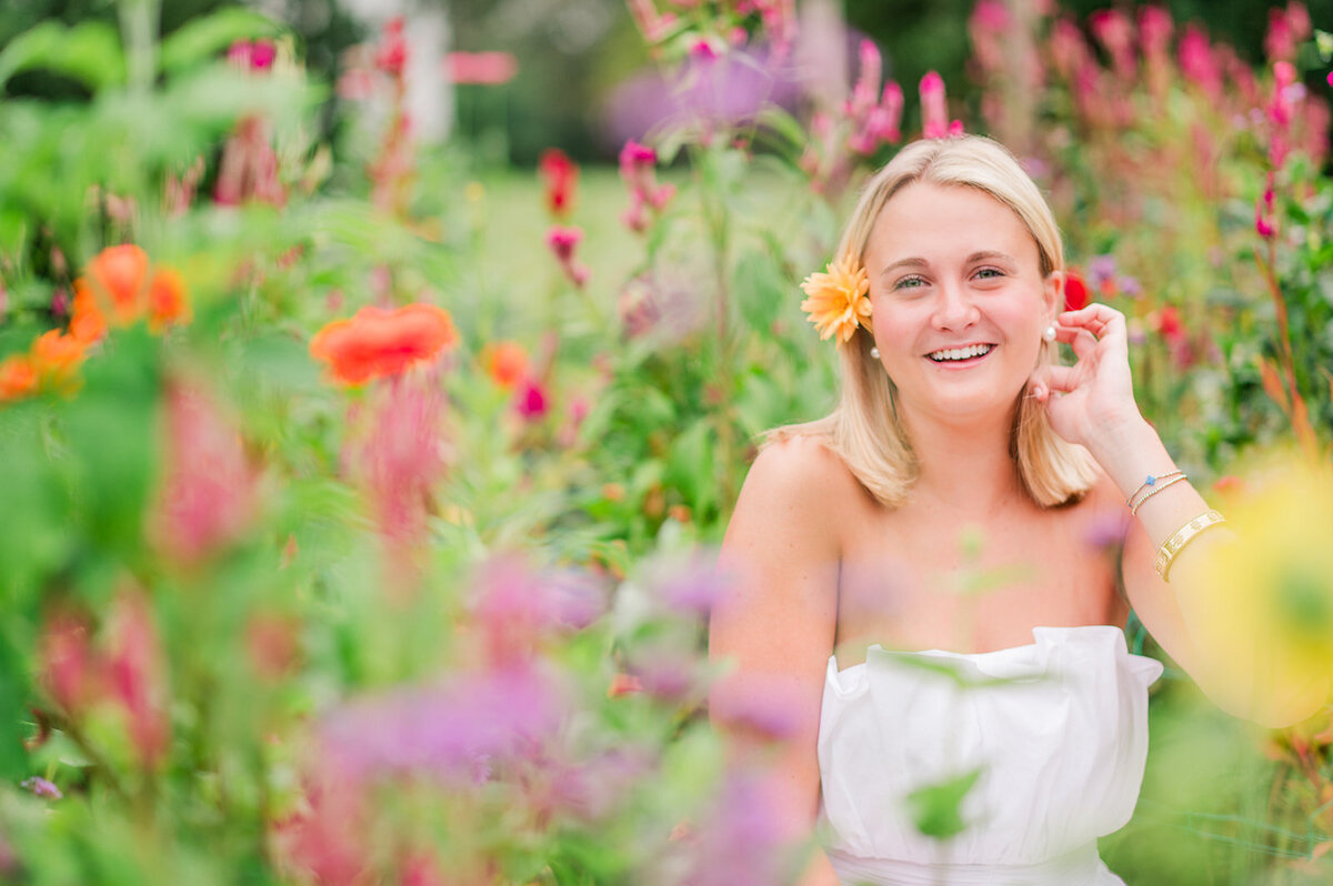 a girl posing by a flower bush