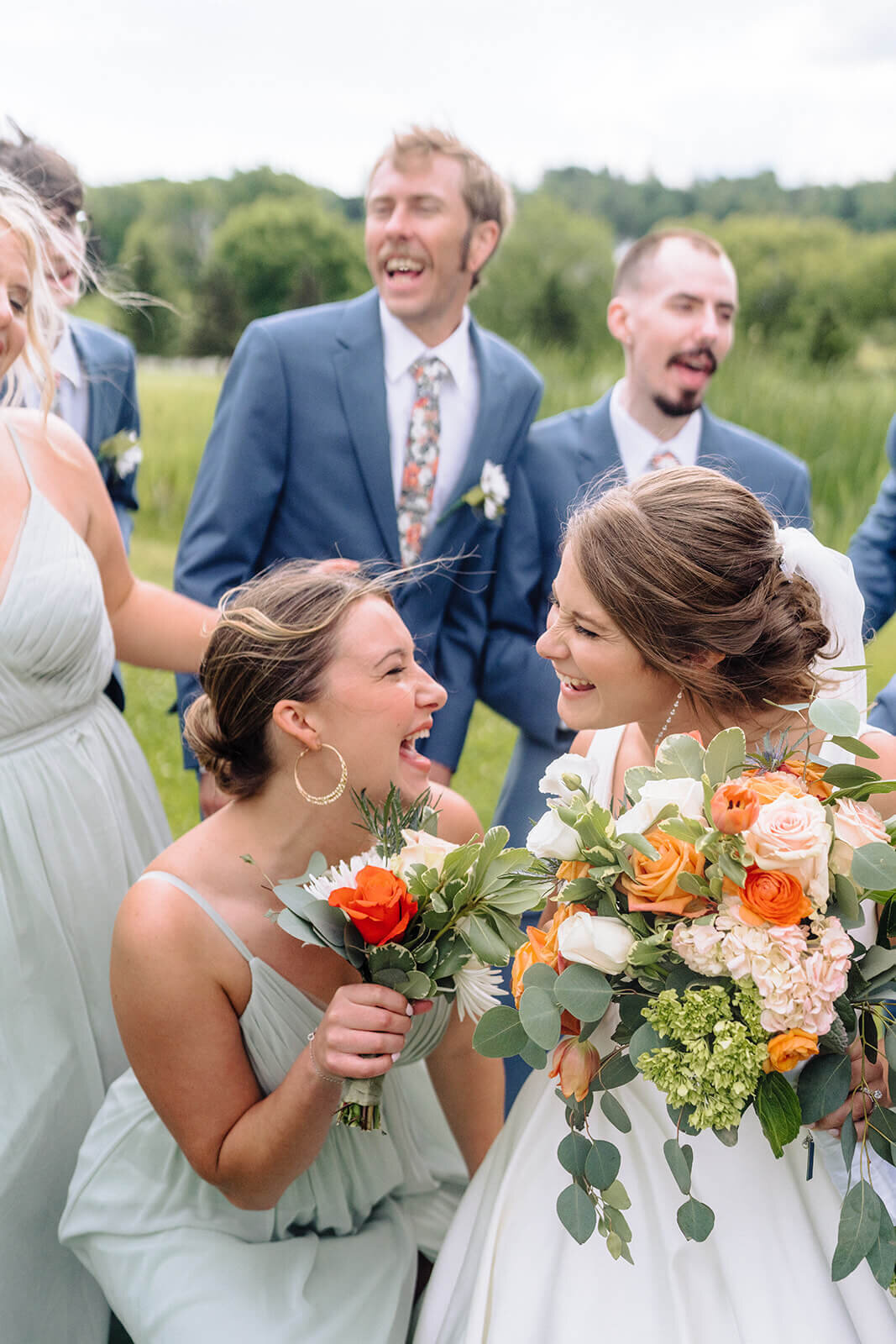 Bride with bridemaids looking at each other and laughing