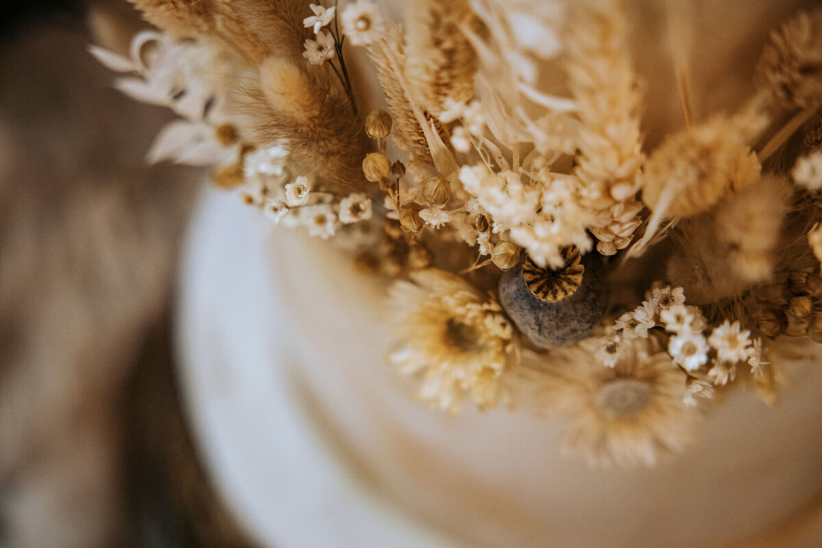 A close up image of dried flowers used to decorate a wedding cake