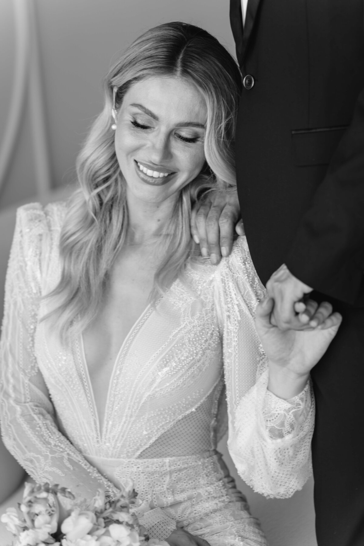 black and white photo of a bride holding her grooms hand