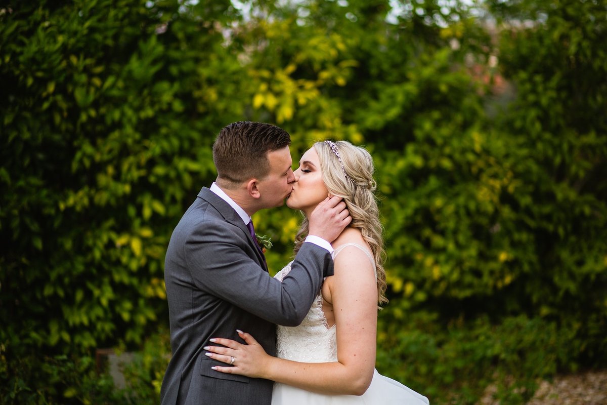 Bride and groom kissing in the courtyard at The Scottsdale Resort by wedding photographer PMA Photography.