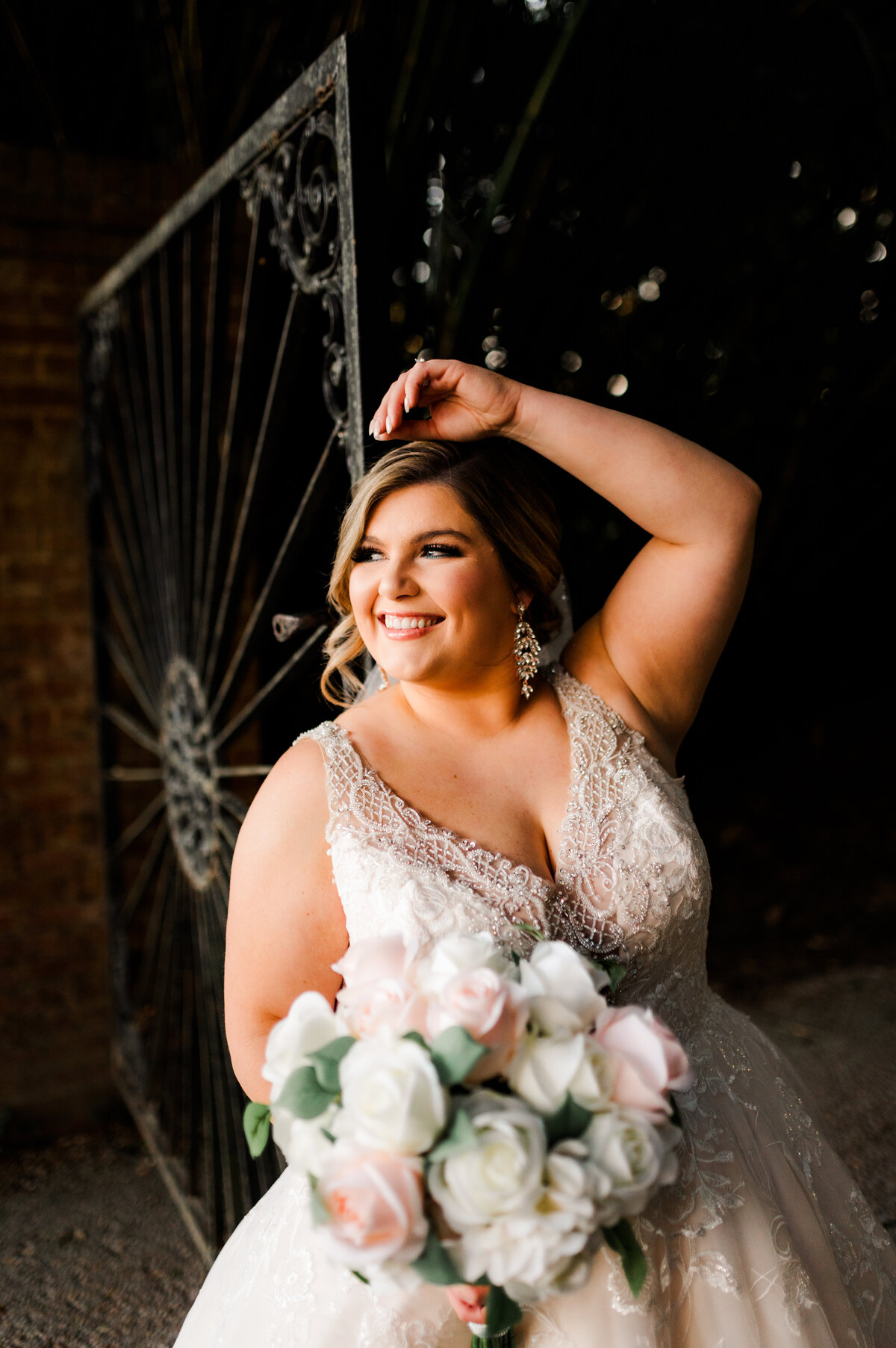 bride standing at a gate in a garden for her little rock wedding bridals