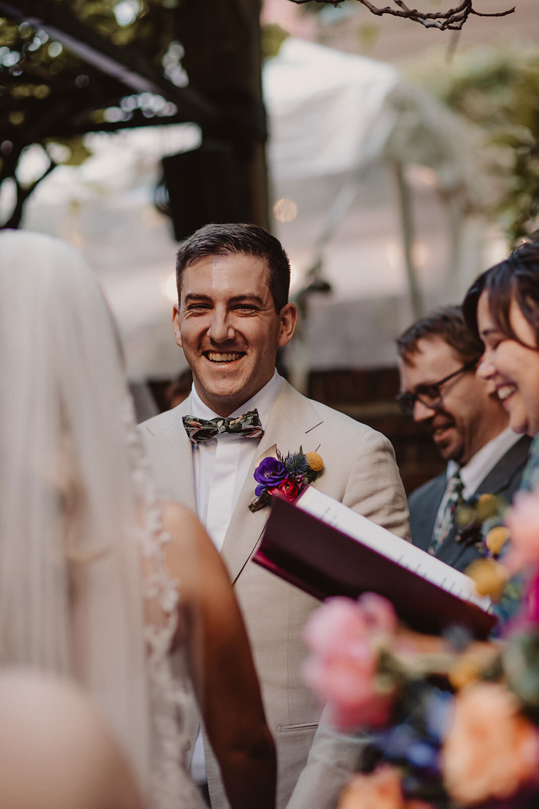 A person smiling as they stand up during their wedding ceremony 
