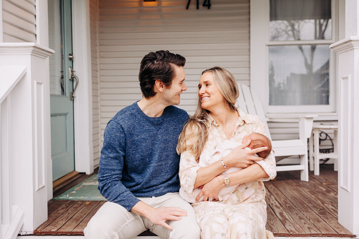 couple on the porch with their newborn baby