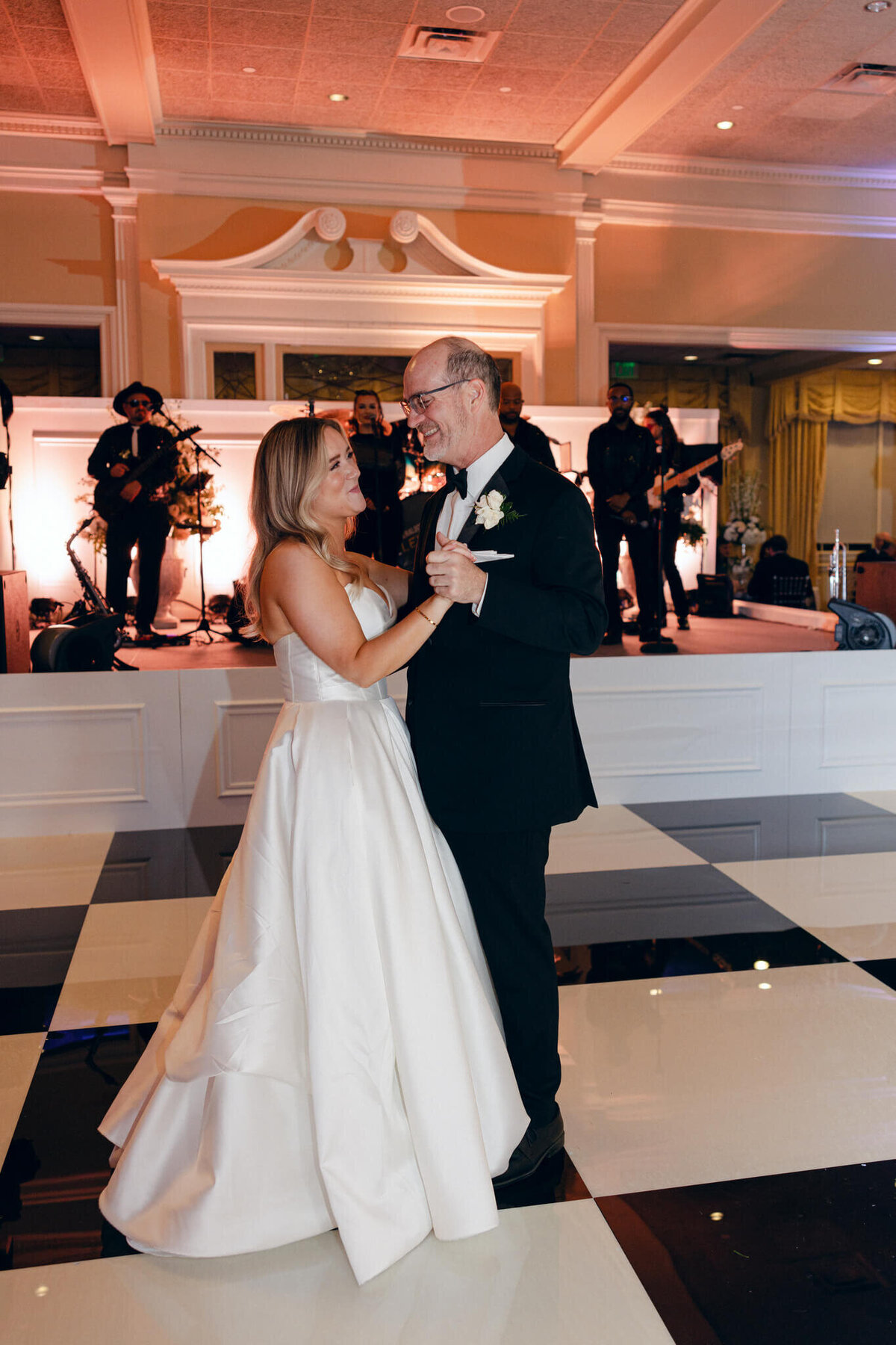 A wedding photo fo the bride dancing with her dad at the reception