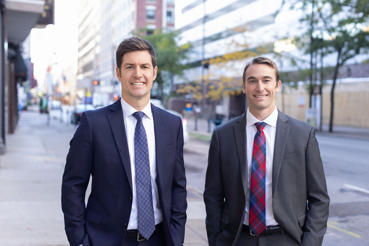 Explore the professional portrait of two confident attorneys in a bustling urban setting. Dressed in sharp suits, they stand side by side, exuding professionalism and trust. Perfect for personal branding and corporate headshots in Cincinnati, this image highlights the expertise of our Cincinnati-based portrait photography studio.