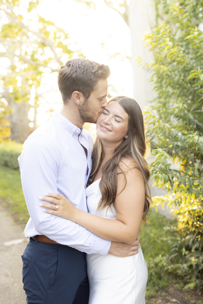 couple embraces in the park for engagement portraits