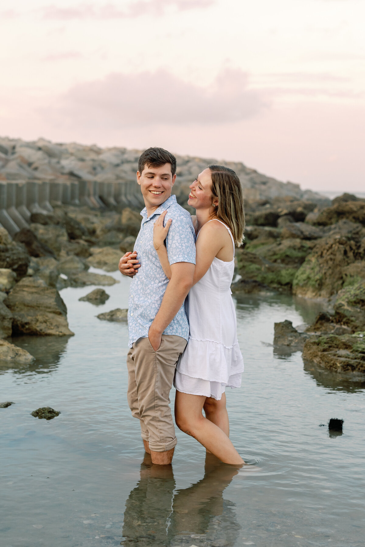 Couple sharing a tender moment on Wilmington beach, candid engagement photography