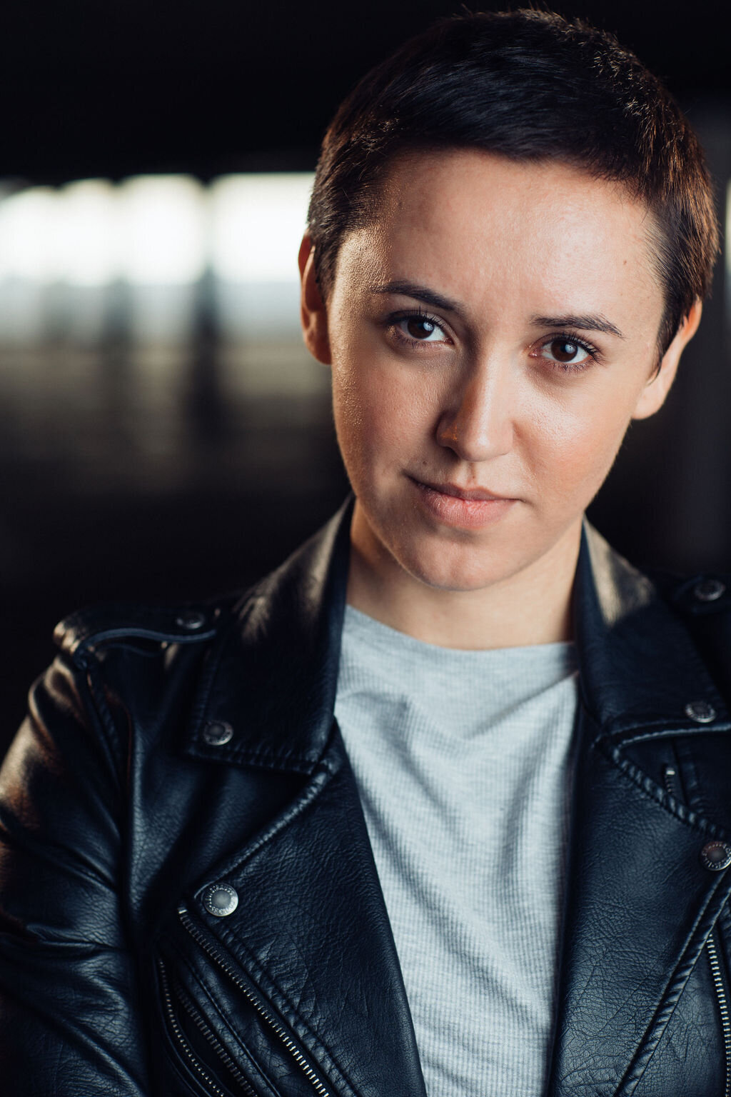 Headshot Photograph Of Young Woman In Outer Black Leather Jacket And Inner Gray Shirt Los Angeles